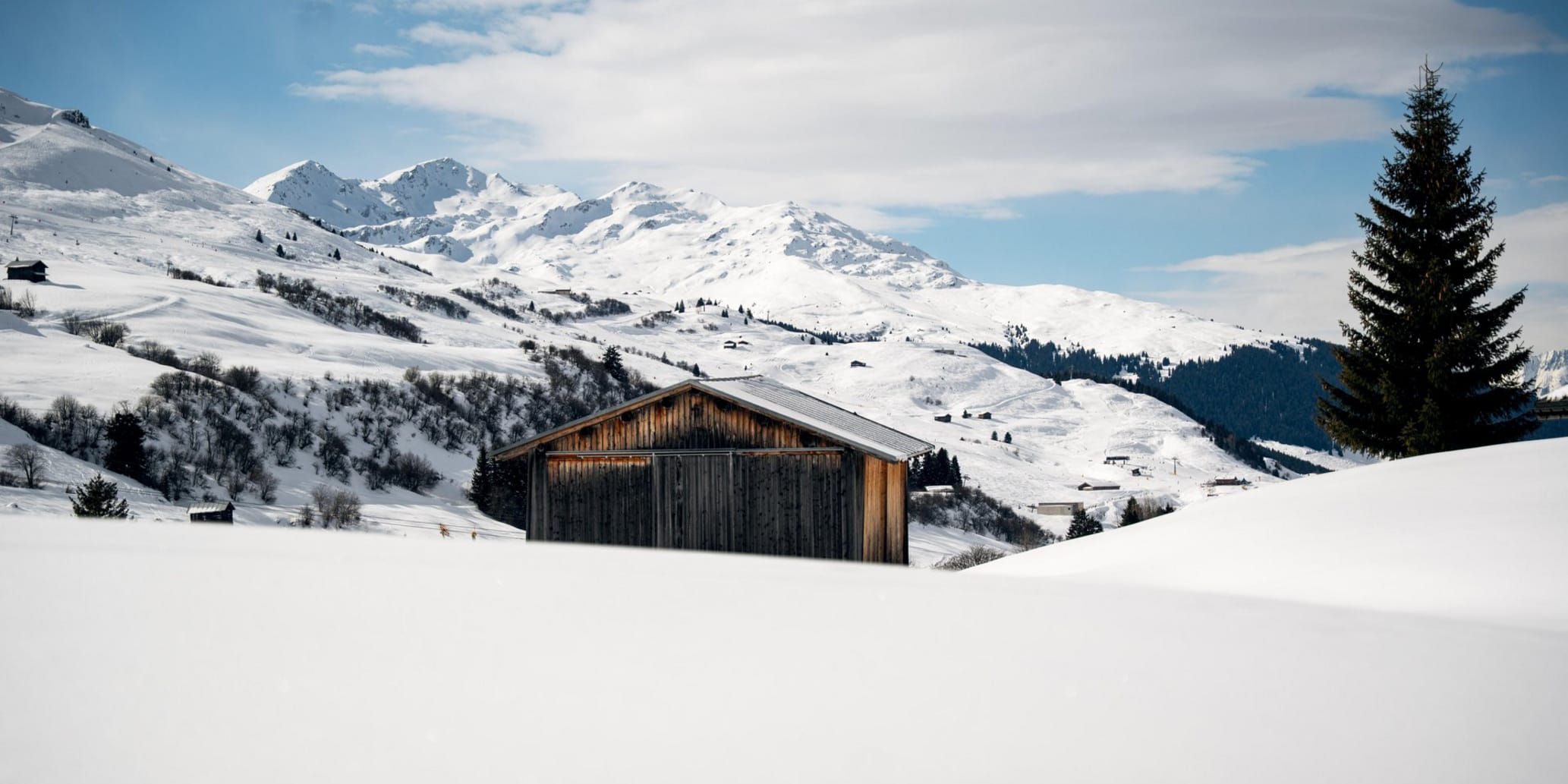 Maiensäss in Schneehügeln im Hintergrund Winterlandschaft
