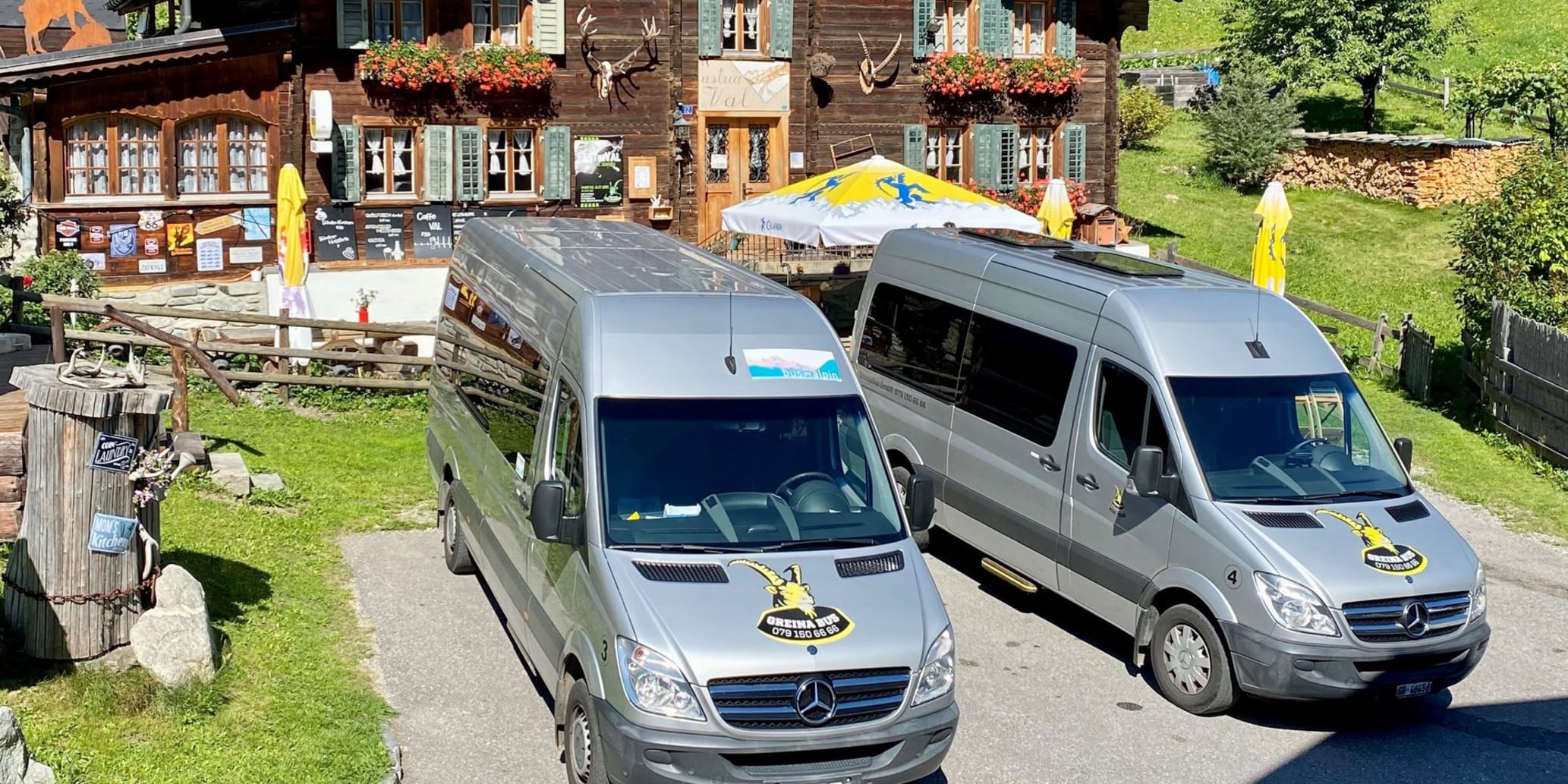 Zwei Shuttlebusse stehen vor Bergrestaurant im Sommer