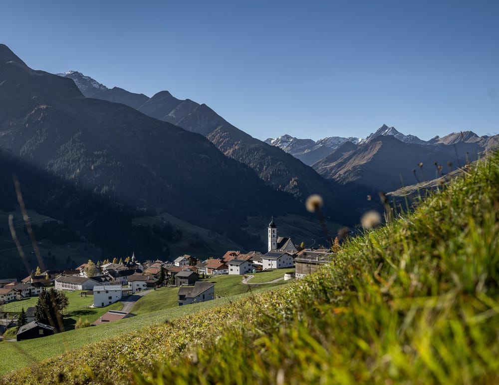 Hinter Wiese hervor Blick auf einen Teil des Dorfes im Sommer