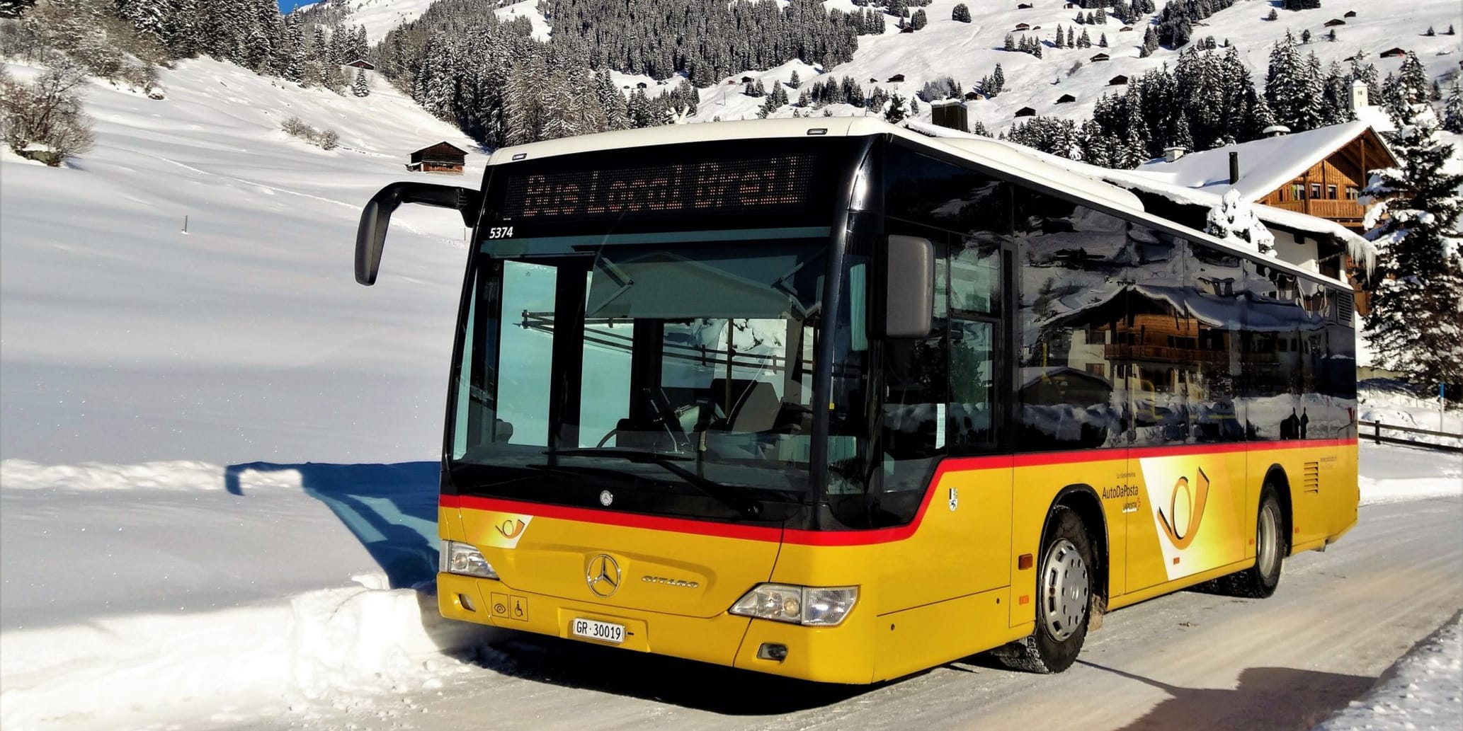 Postauto im Winter auf Strasse Ausserorts
