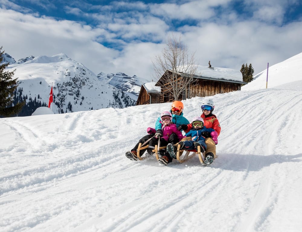 Familie auf Schlittelpiste