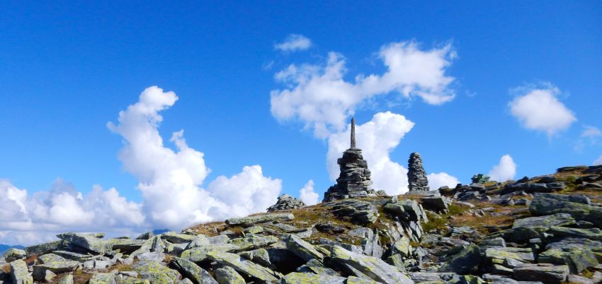 Ein Steinmeer mit Steinmännchen. Im Hintergrund blauer Himmel mit Wolken.